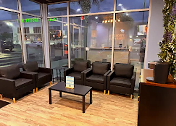 Sala de espera de Prosper Urgent Care con sillas de cuero y ventanales